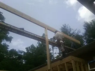 Carpenter setting a ridge beam over a new addition frame — Ice Dam Removal by Roofing Brothers in Allerton