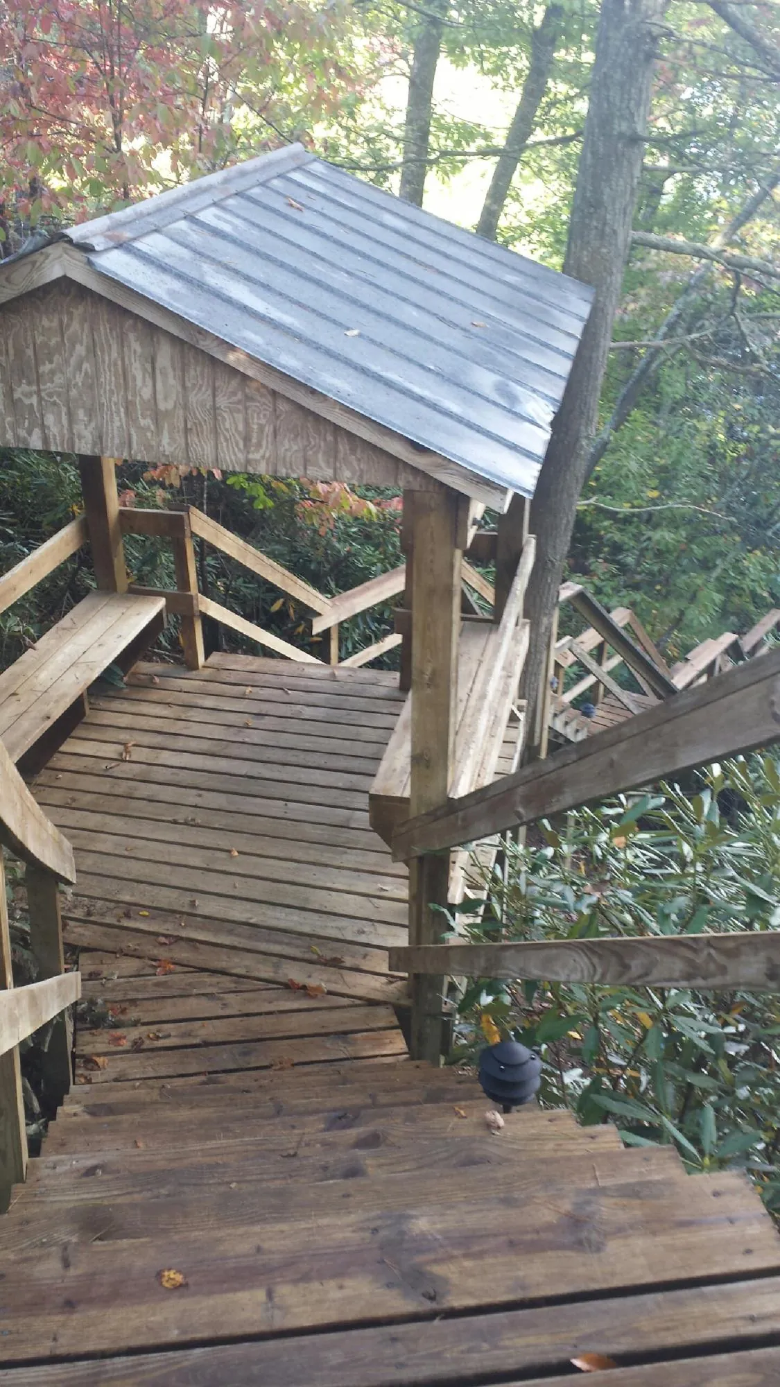 Metal roofed shelter over wooden steps on a wooded walkway — Skylight Repair & Installation work by our crew in Allerton