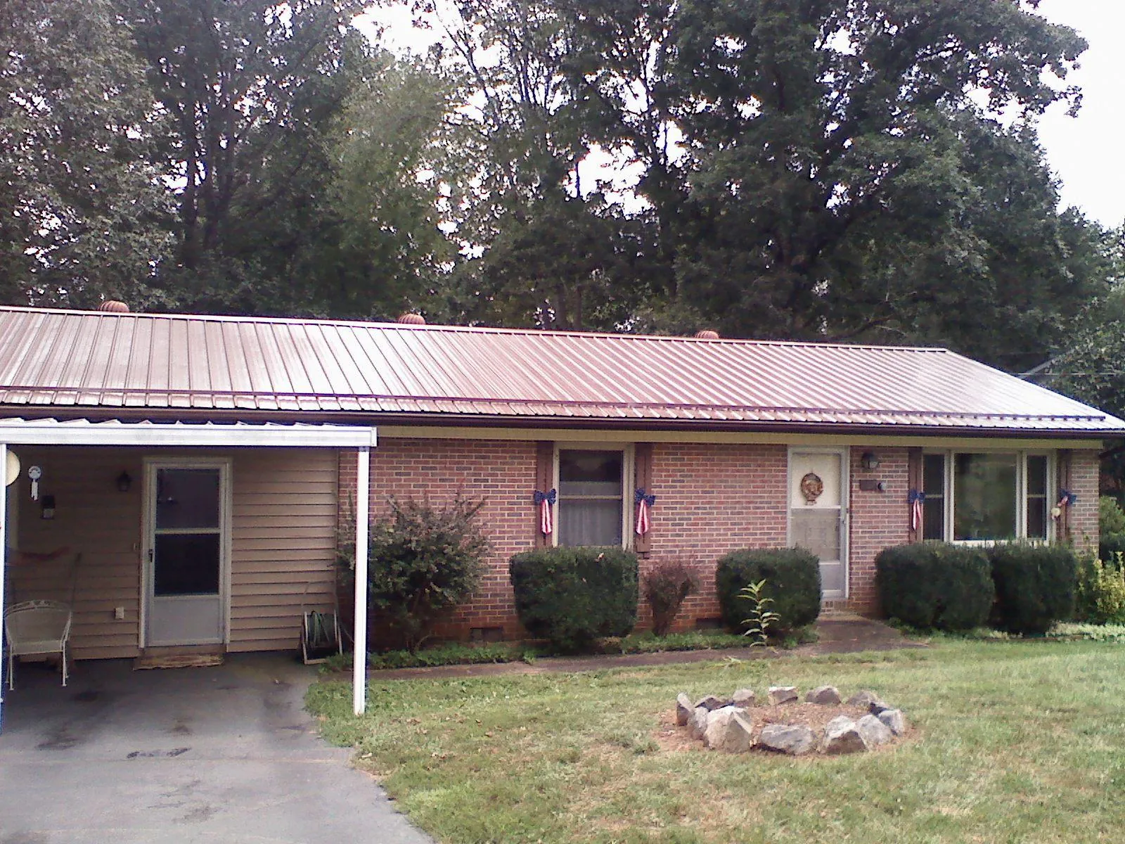 Bronze metal roof and carport on a brick ranch home — Roof Repair work by our crew in Allerton